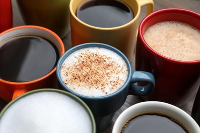 Photo of Many different cups with aromatic hot coffee on table, closeup