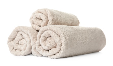 Photo of Rolled clean beige towels on white background