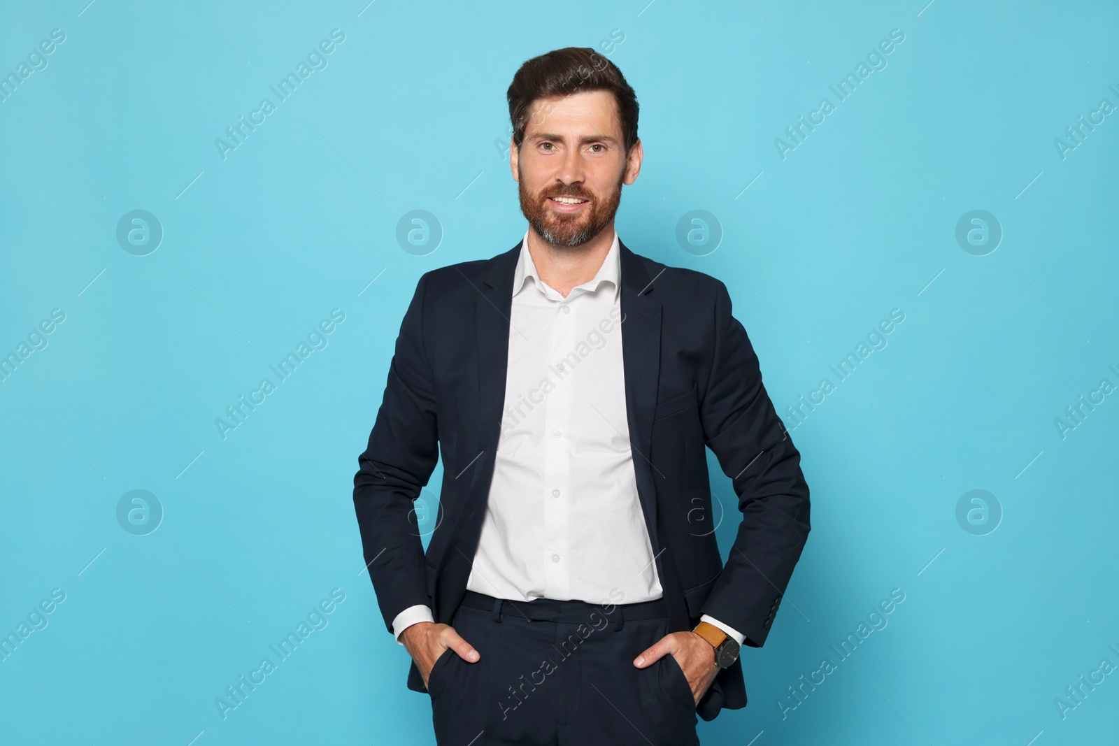 Photo of Portrait of handsome bearded man in suit on light blue background