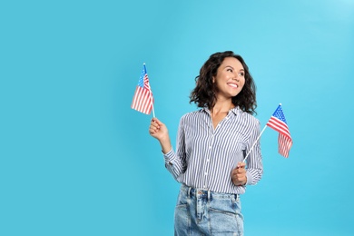 Photo of happy young woman with USA flag on blue background. Space for text