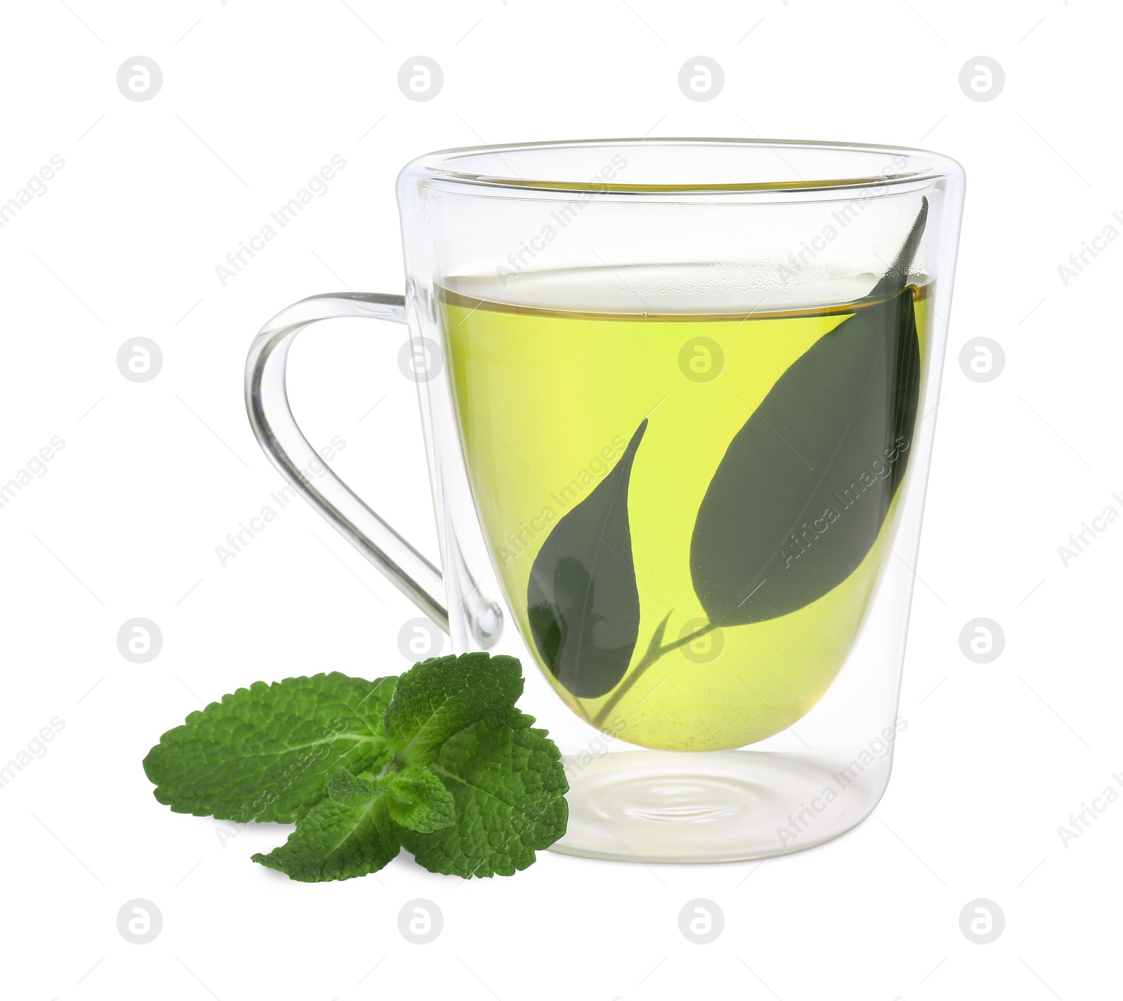 Photo of Fresh green tea in glass mug, leaves and mint isolated on white