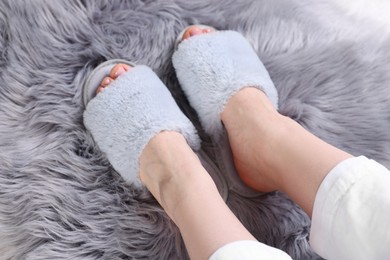 Photo of Woman in grey soft slippers at home, closeup