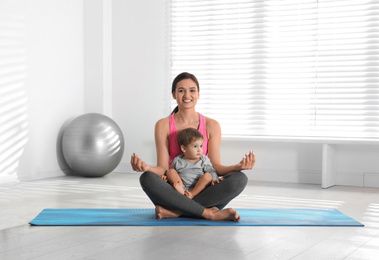 Young woman meditating with her son at home