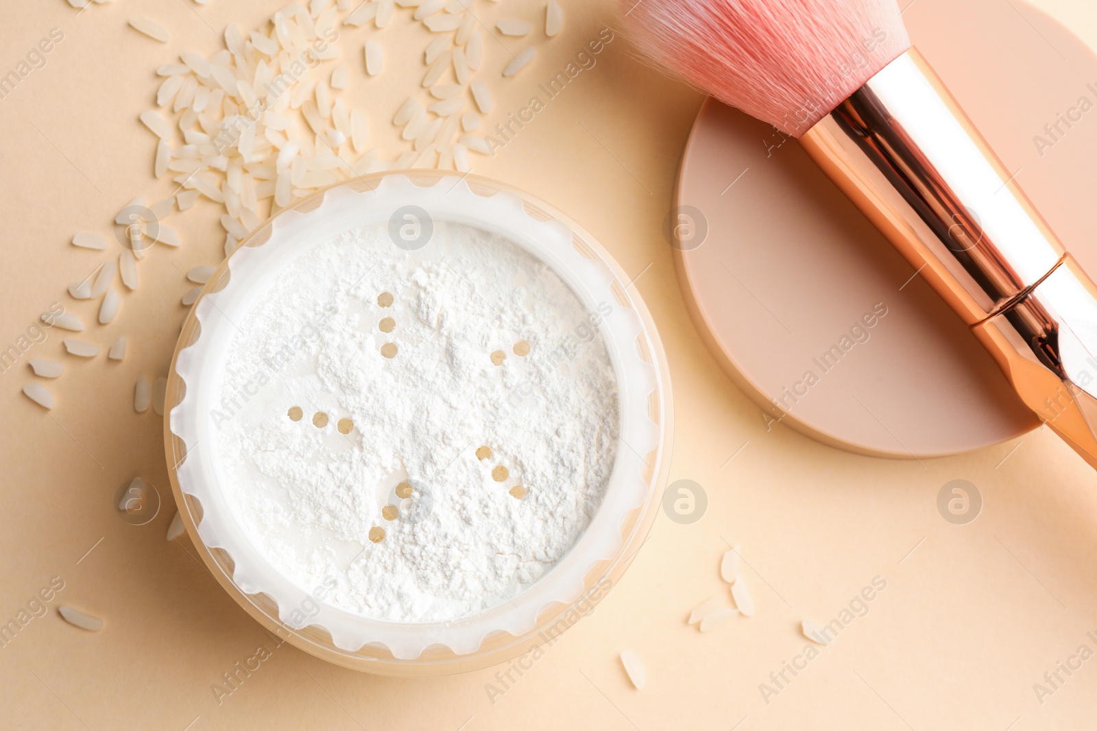 Photo of Loose face powder, rice and makeup brush on beige background, flat lay
