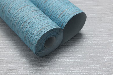 Photo of Light blue wallpaper roll on grey sample, space for text