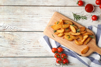 Photo of Flat lay composition with baked potatoes, rosemary and tomatoes on wooden background. Space for text