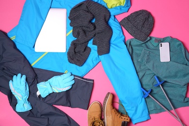 Set of warm sports clothes and devices on color background, flat lay. Winter vacation