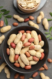 Fresh peanuts and twigs on grey table, flat lay