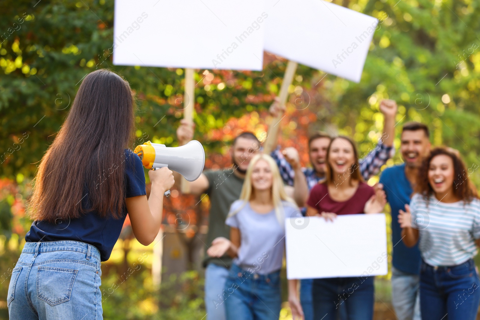 Photo of Female meeting leader with megaphone talking to crowd outdoors