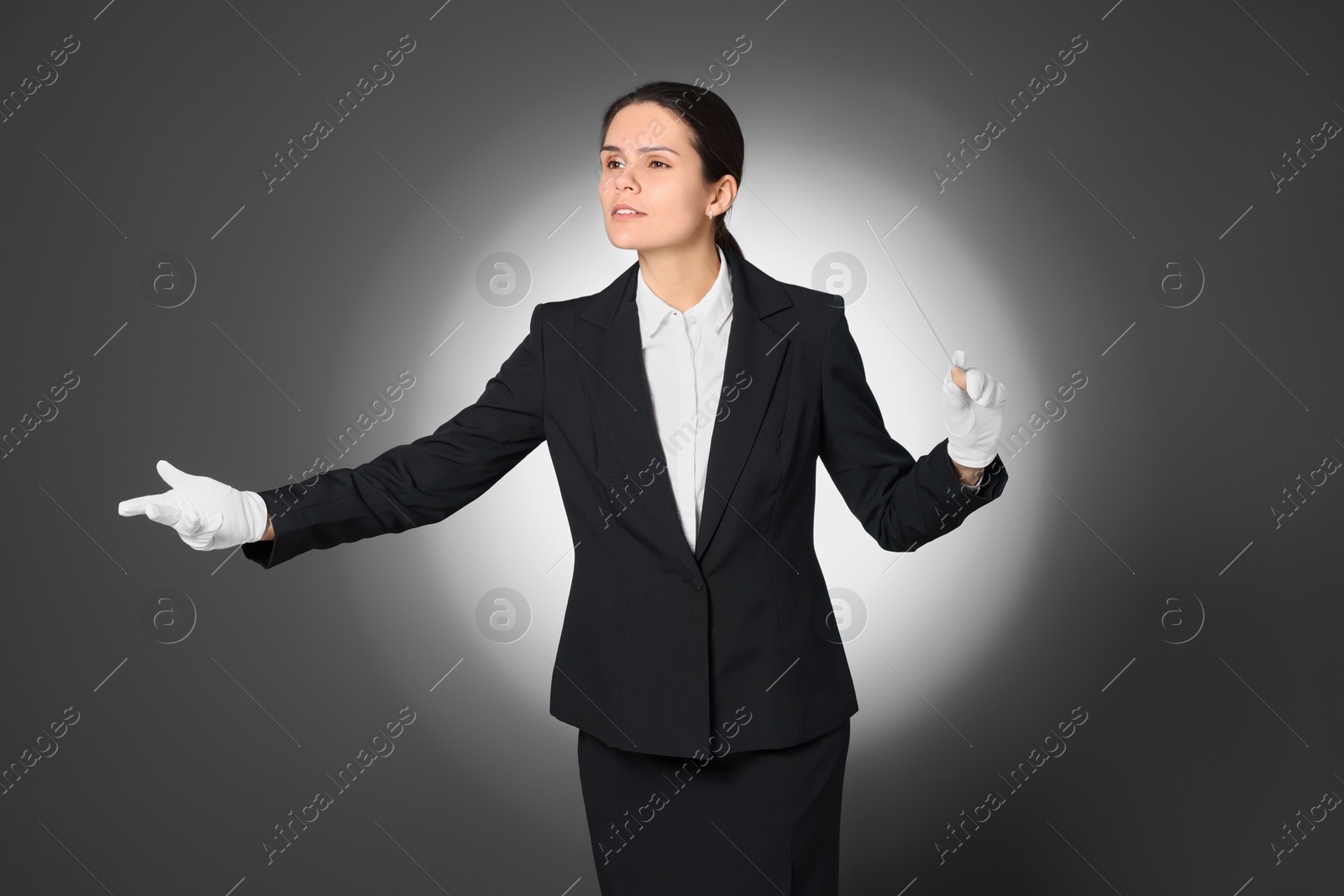 Photo of Professional conductor with baton on grey background