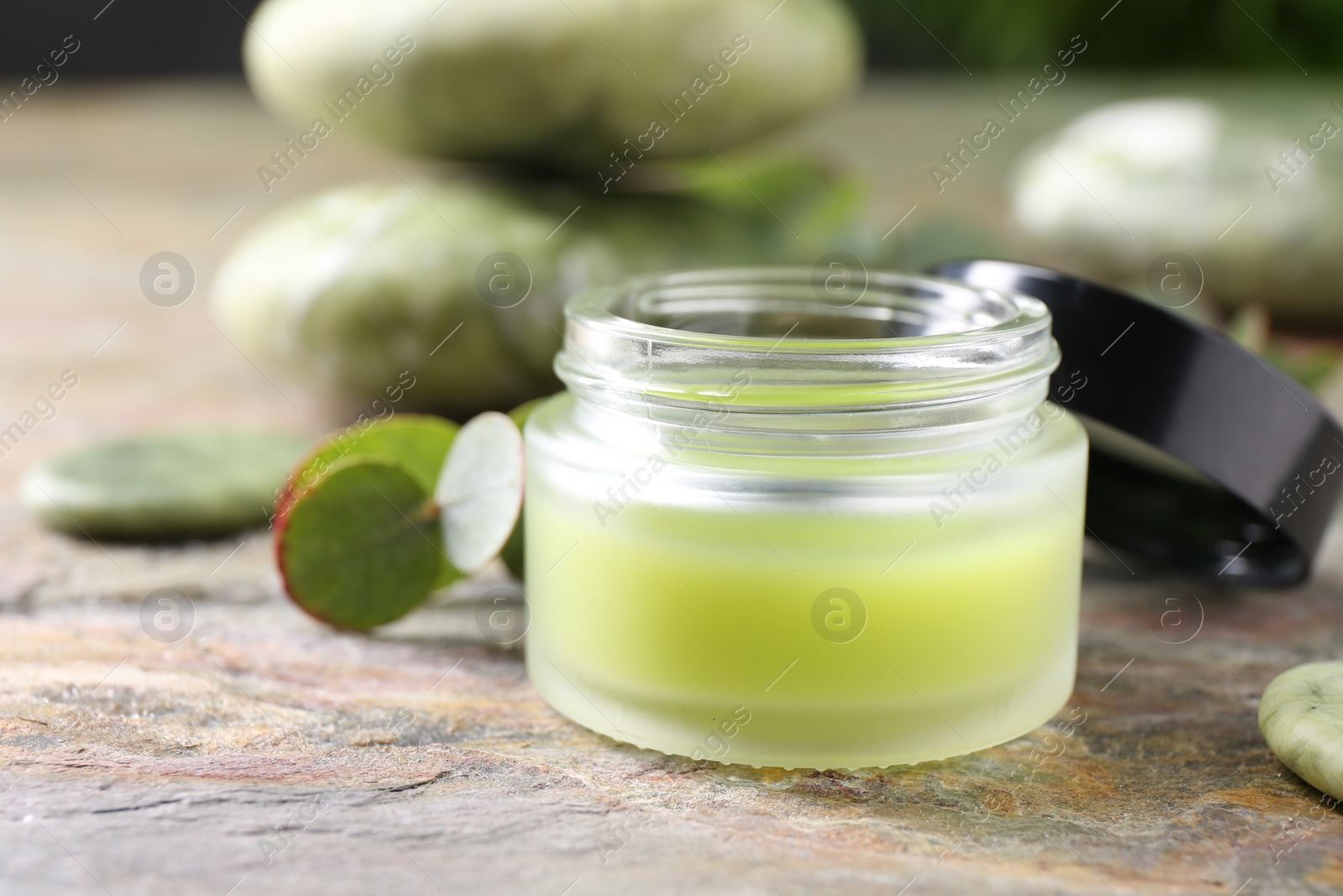 Photo of Jar of cream on textured table, closeup. Body care product