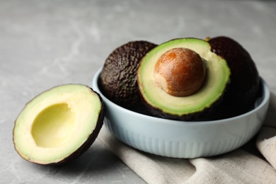 Delicious ripe avocados on grey marble table