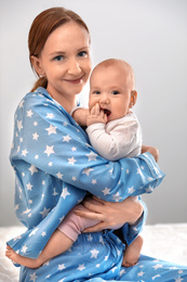 Photo of Young woman with her little baby resting after breast feeding on bed