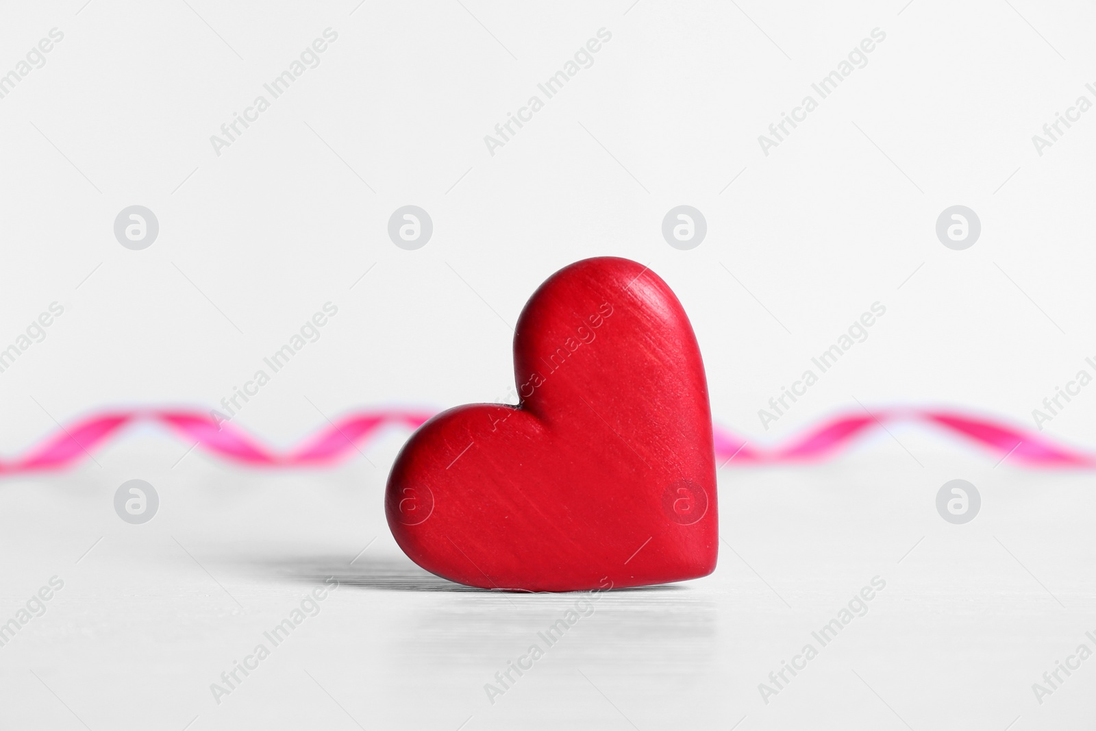 Photo of Red decorative heart as symbol of love on table