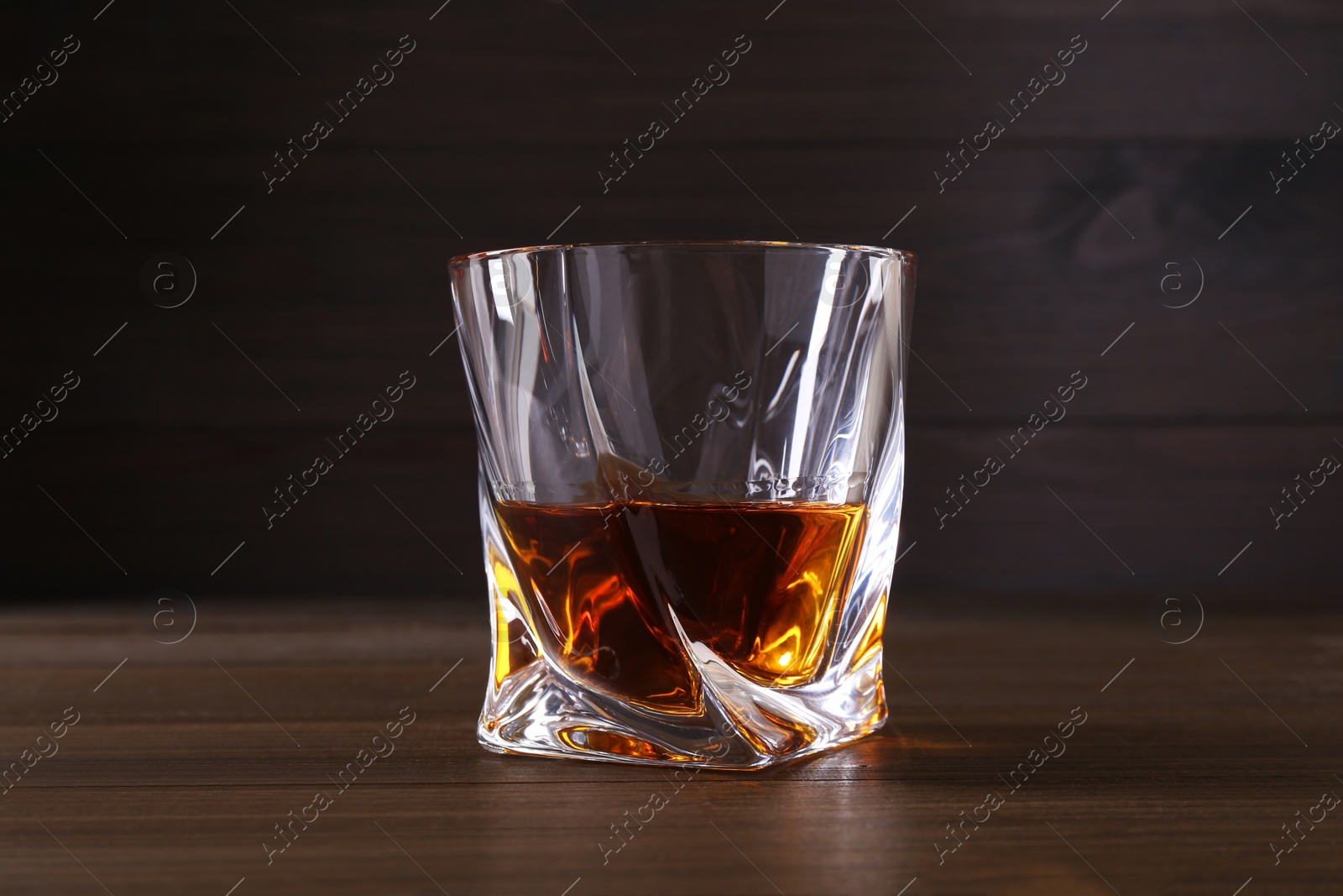 Photo of Delicious liqueur in glass on wooden table