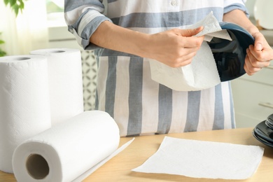 Photo of Woman wiping ceramic bowl with paper towel indoors, closeup