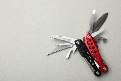 Compact portable multitool on light grey background, top view. Space for text
