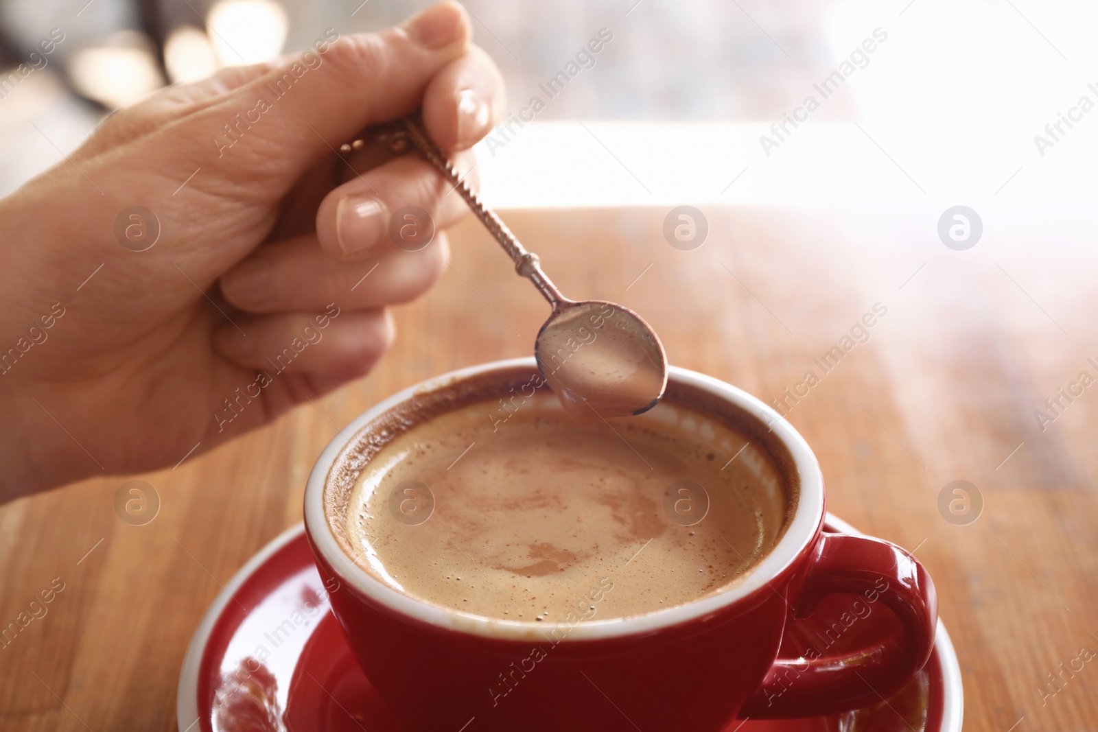 Photo of Woman with cup of fresh aromatic coffee at table, closeup