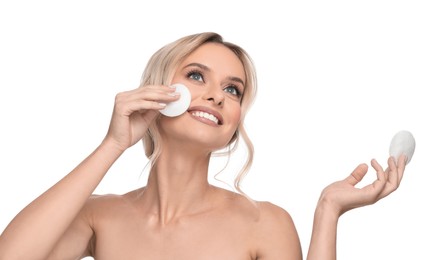 Smiling woman removing makeup with cotton pads on white background