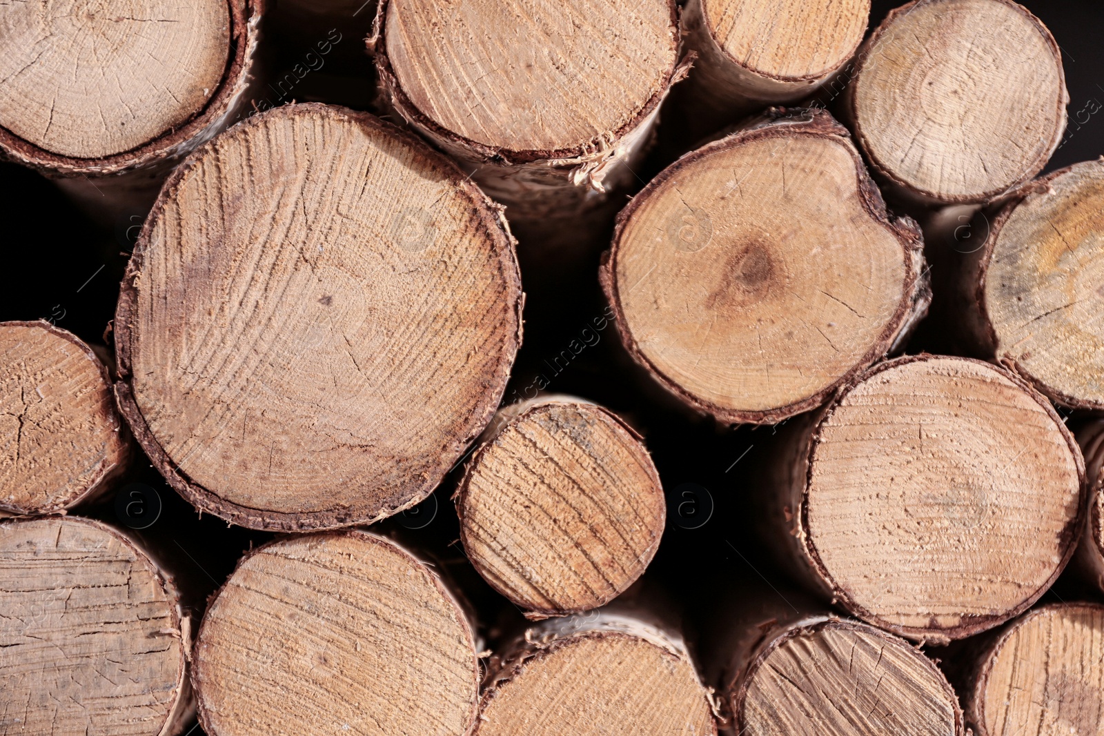 Photo of Stacked firewood as background, closeup view. Decorative material