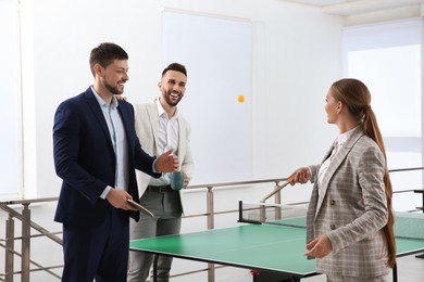 Business people talking near ping pong table in office