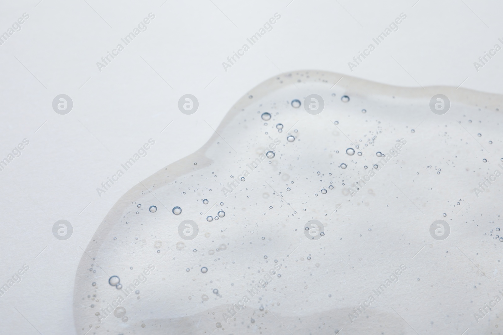 Photo of Sample of cosmetic oil on beige background, closeup