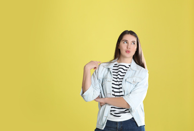 Photo of Portrait of young woman on yellow background. Space for text