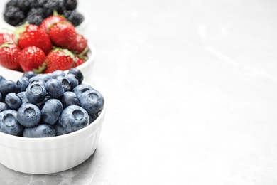 Photo of Different ripe berries on light table, closeup. Space for text