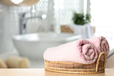 Image of Fresh towels on wooden table in bathroom. Space for text