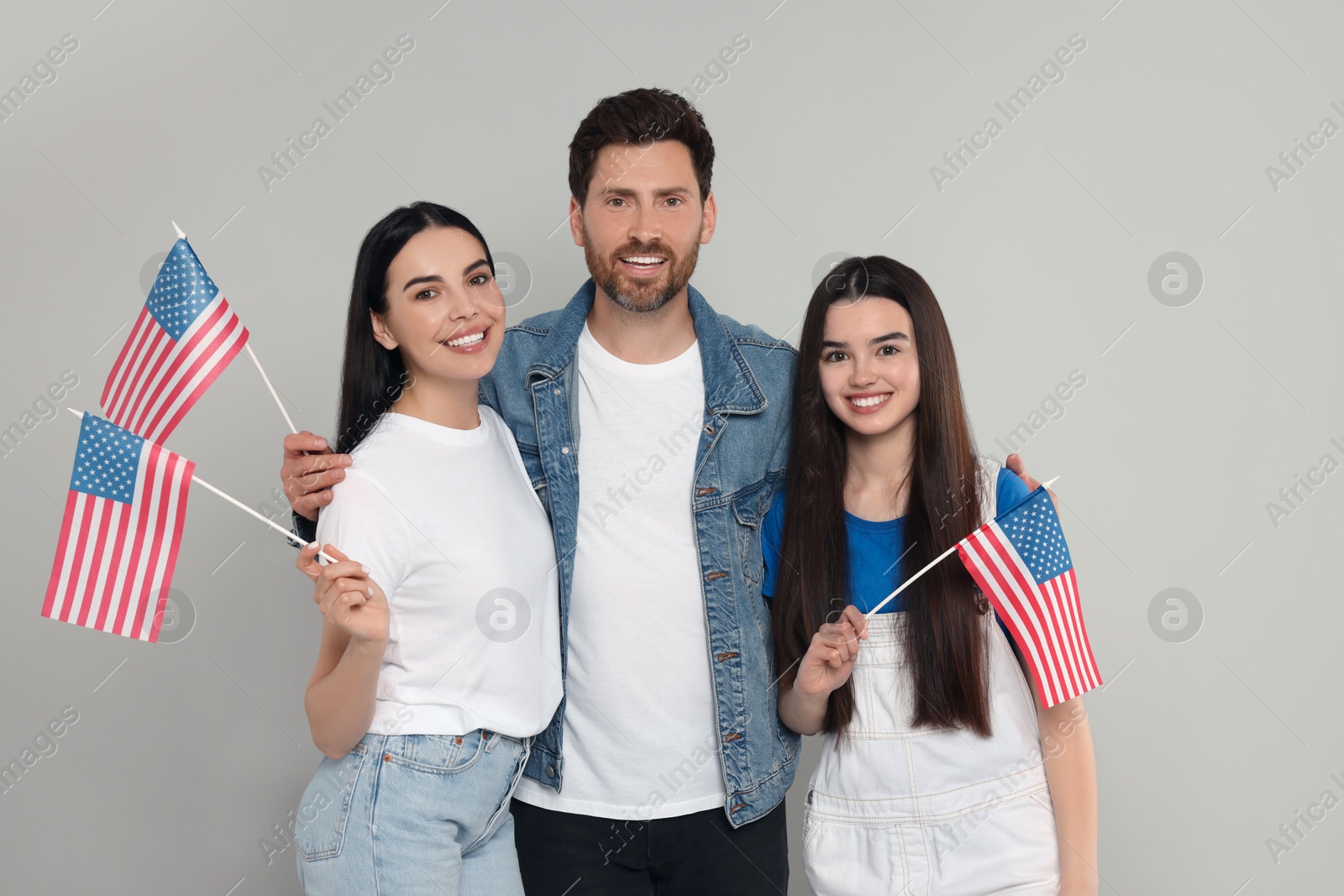 Photo of 4th of July - Independence Day of USA. Happy family with American flags on grey background