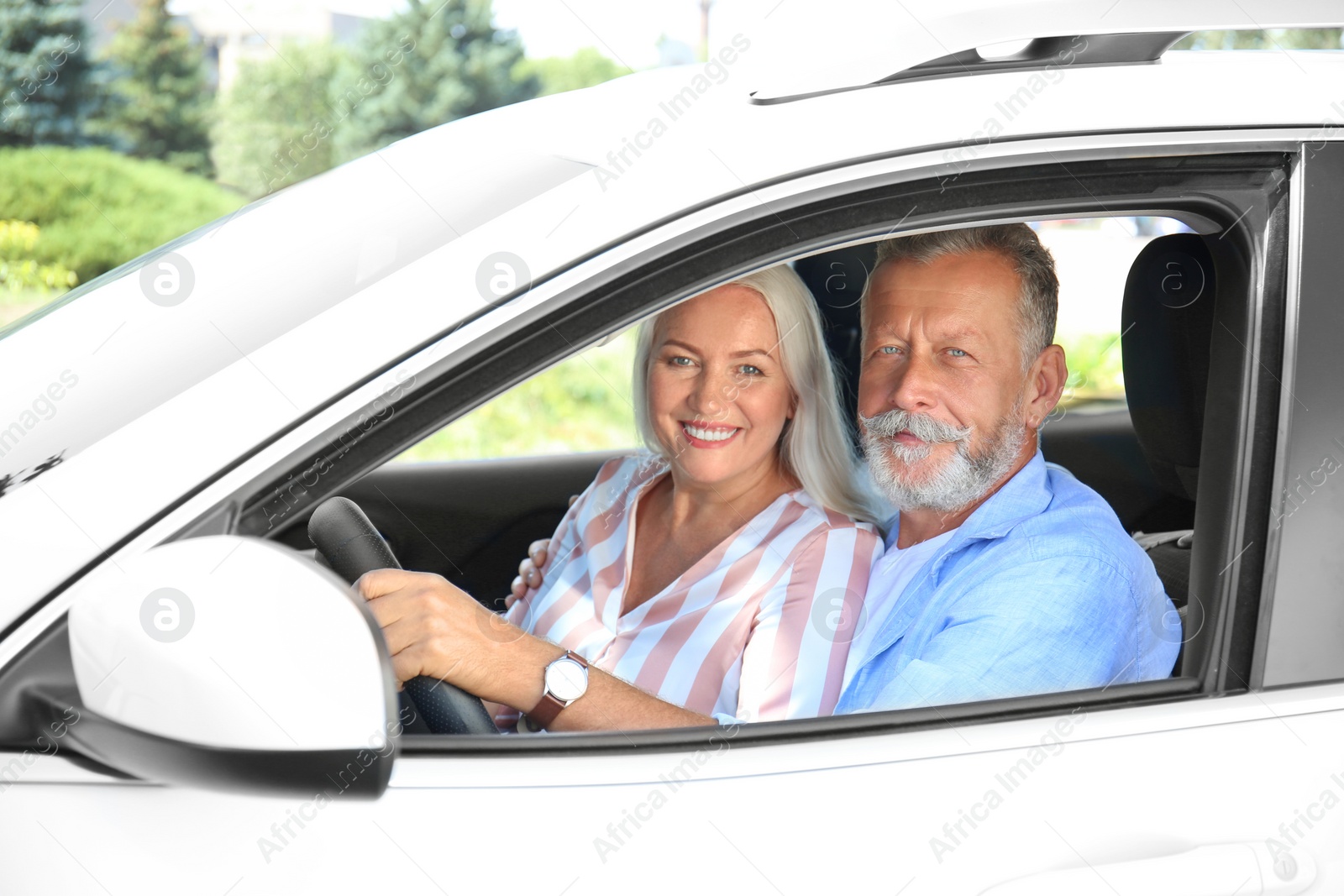 Photo of Happy senior couple travelling together in car