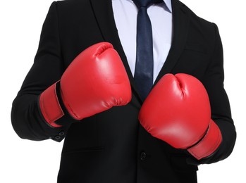 Businessman in suit wearing boxing gloves on white background, closeup