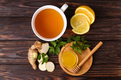 Photo of Flat lay composition of tea with mint, honey, lemon and ginger on wooden table