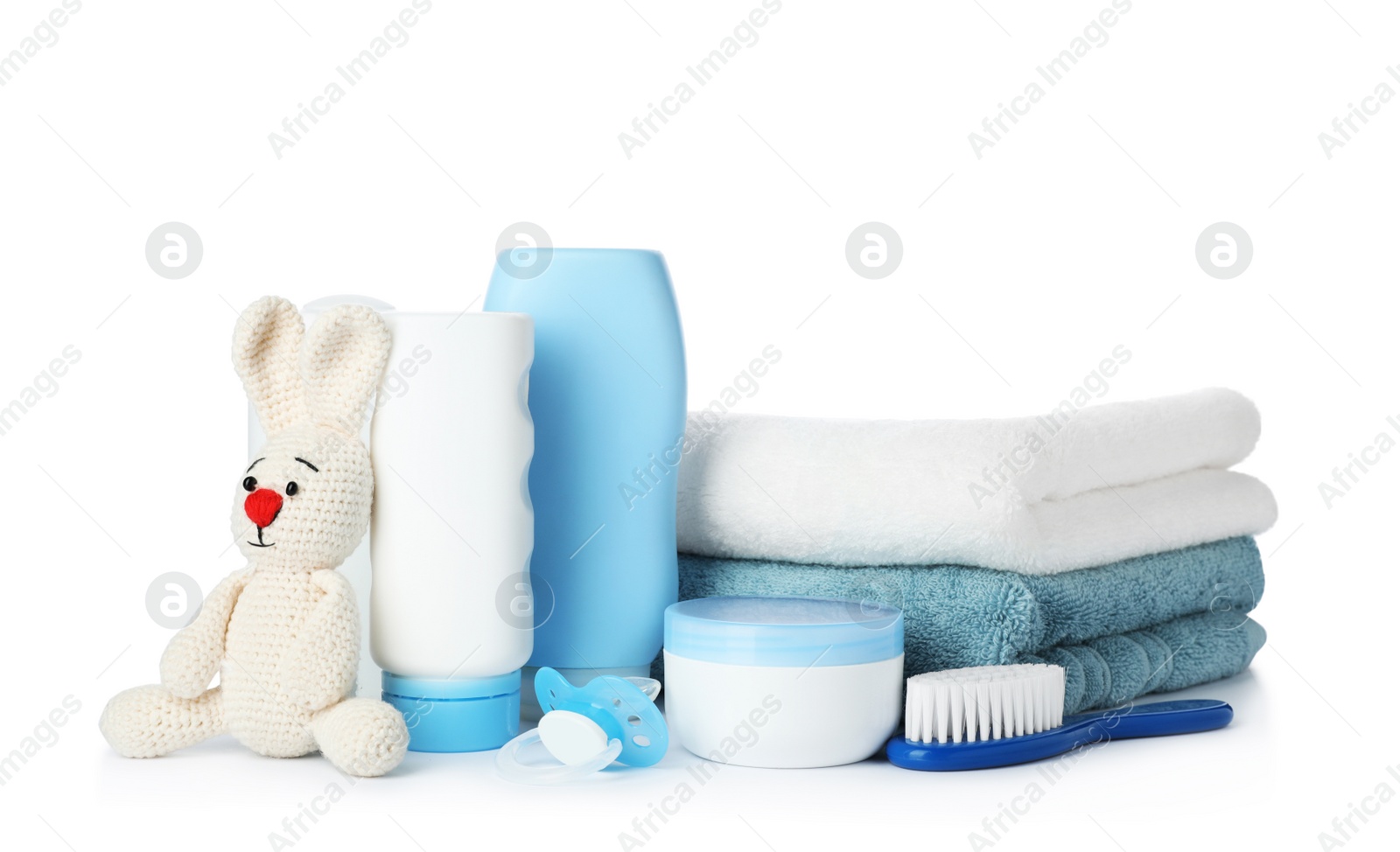 Photo of Baby cosmetic products, toy and towels on white background