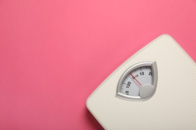 Photo of Weigh scales on pink background, top view with space for text. Overweight concept