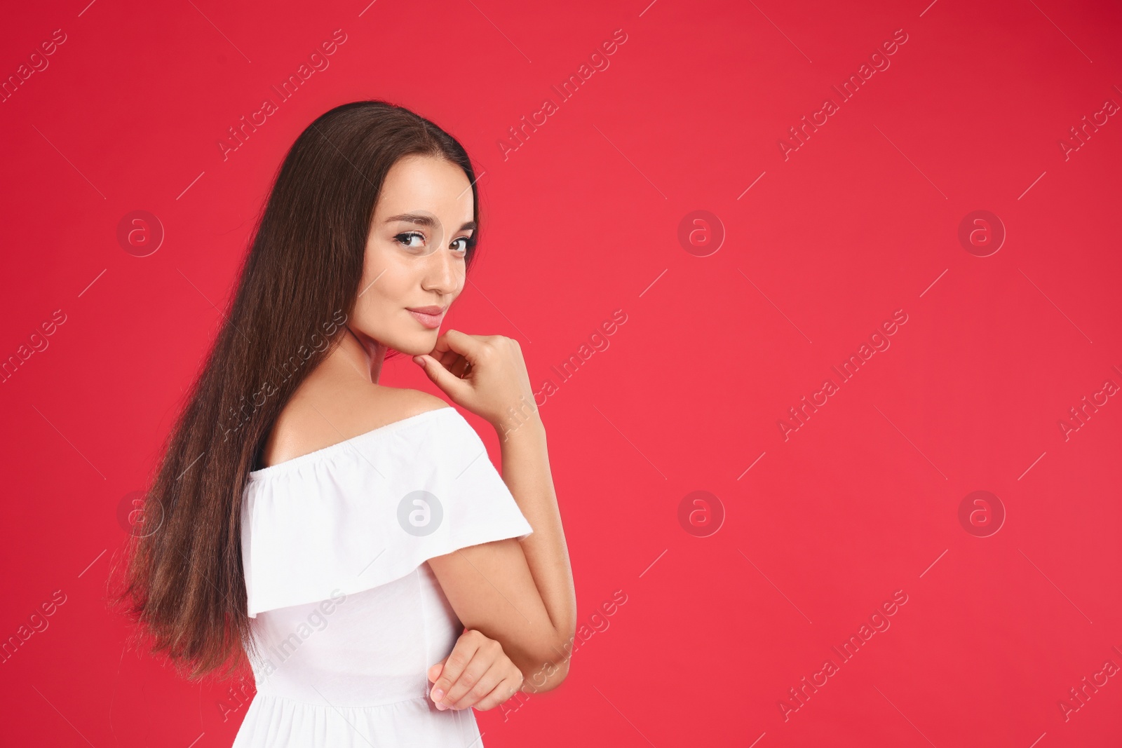 Photo of Young woman wearing stylish white dress on red background. Space for text