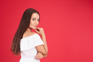 Photo of Young woman wearing stylish white dress on red background. Space for text
