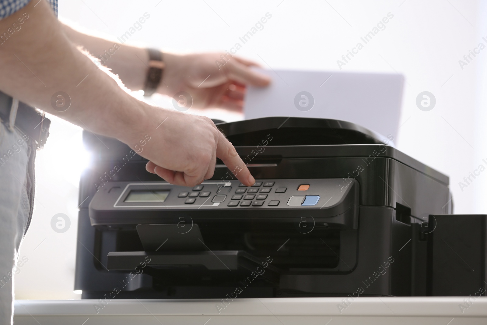 Photo of Employee using modern printer in office, closeup