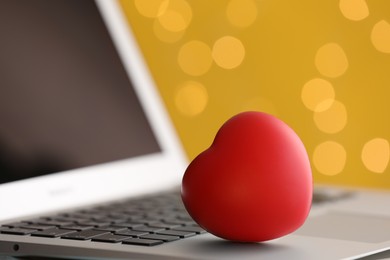 Photo of Red decorative heart on laptop, closeup. Online dating