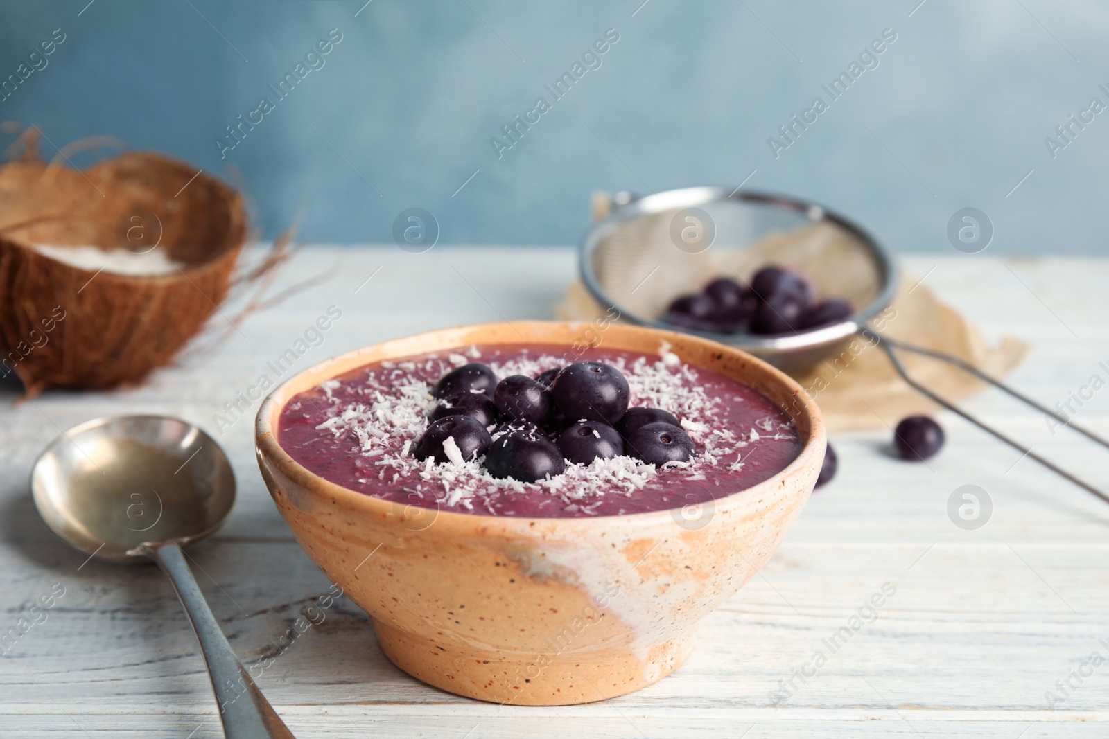 Photo of Bowl with tasty acai smoothie on wooden table