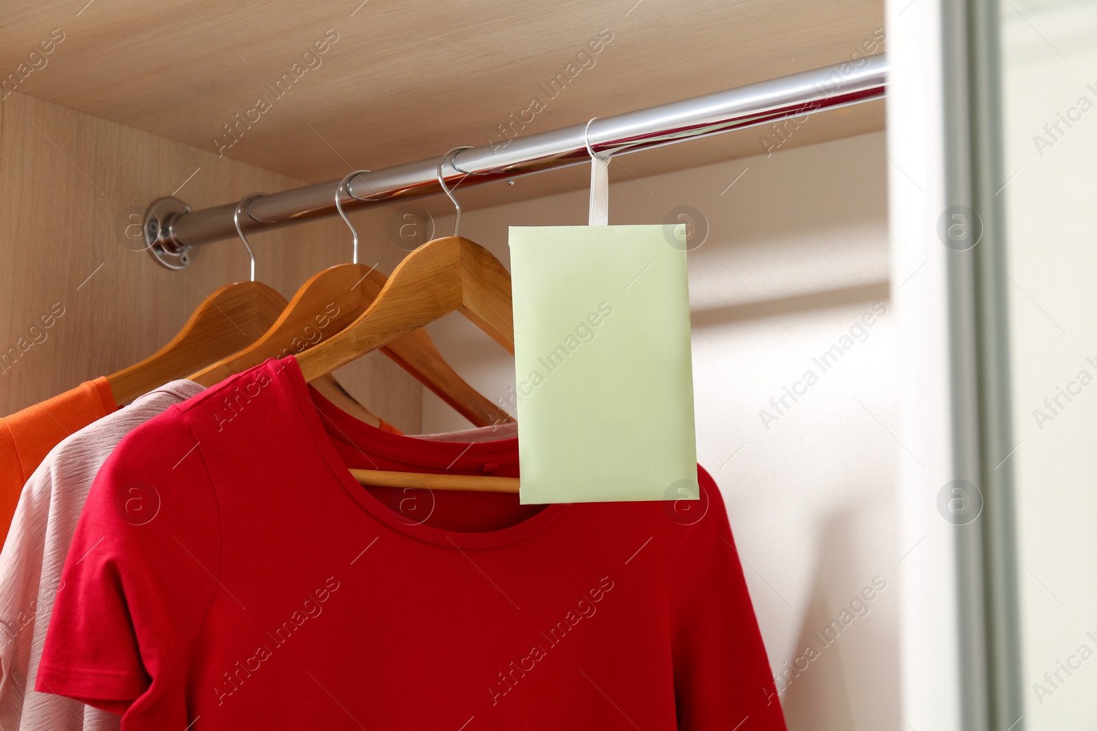 Photo of Scented sachet and clothes hanging in wardrobe
