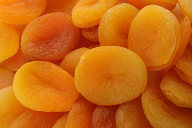 Tasty dried apricots as background, top view