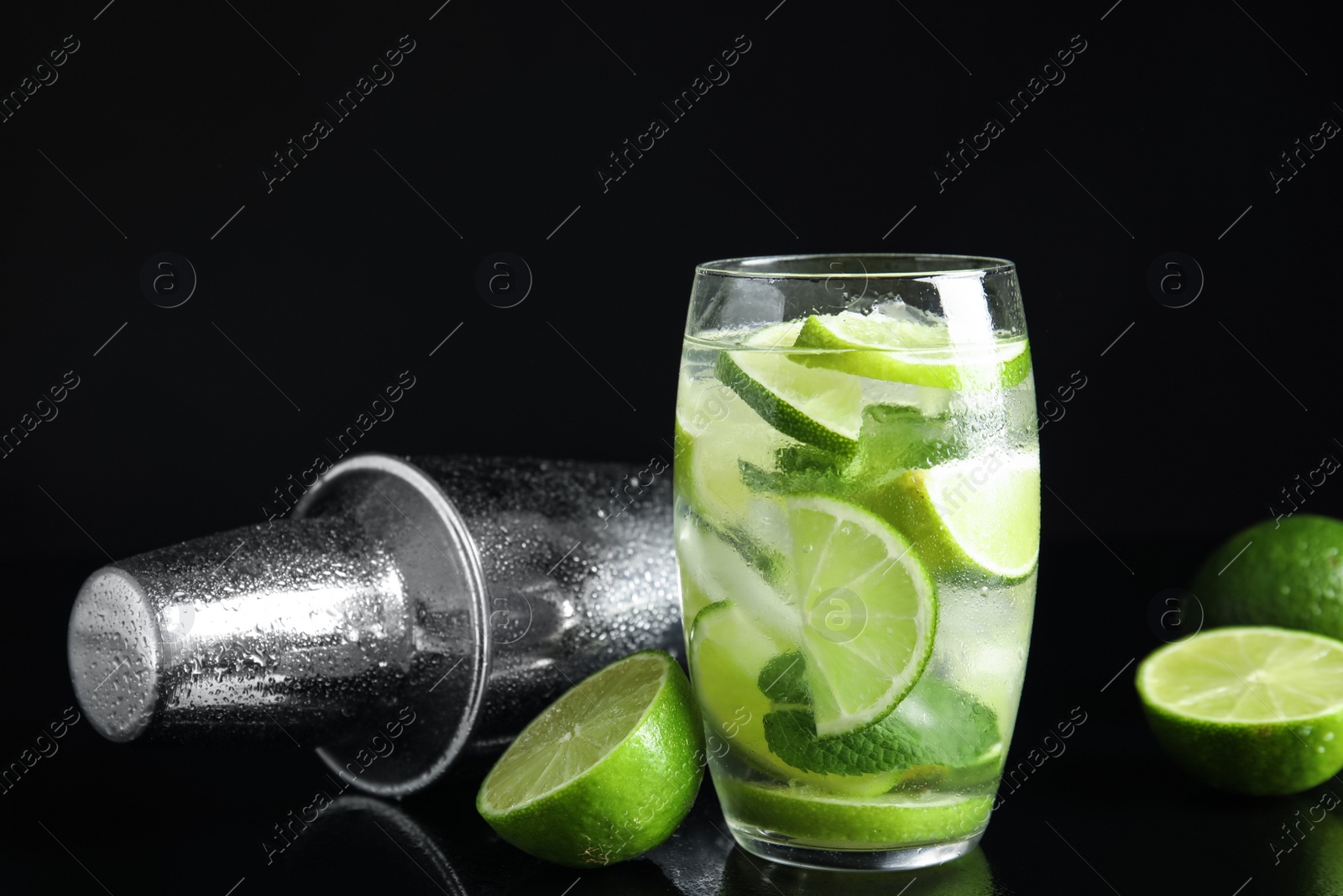 Photo of Delicious mojito and ingredients on black background