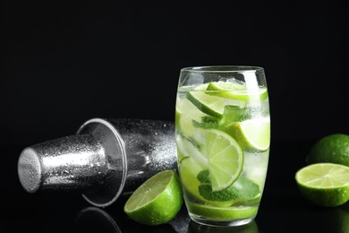 Delicious mojito and ingredients on black background