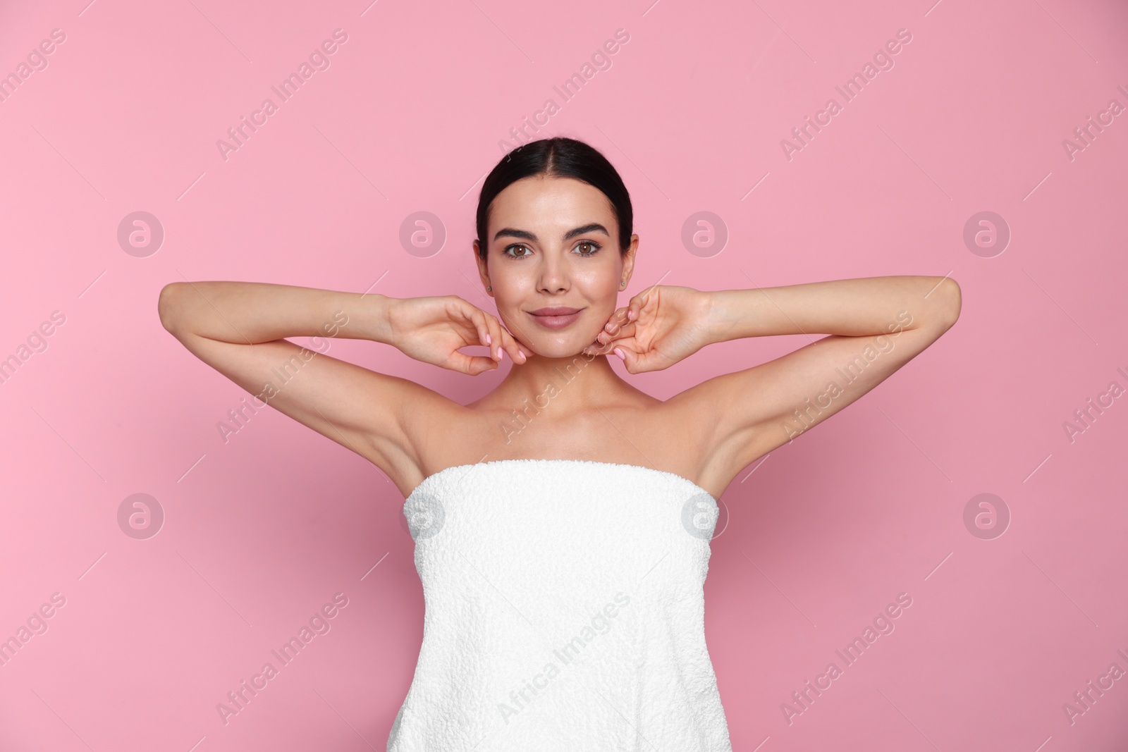 Photo of Young woman showing smooth skin after epilation on pink background