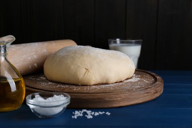 Fresh yeast dough and ingredients on blue wooden table