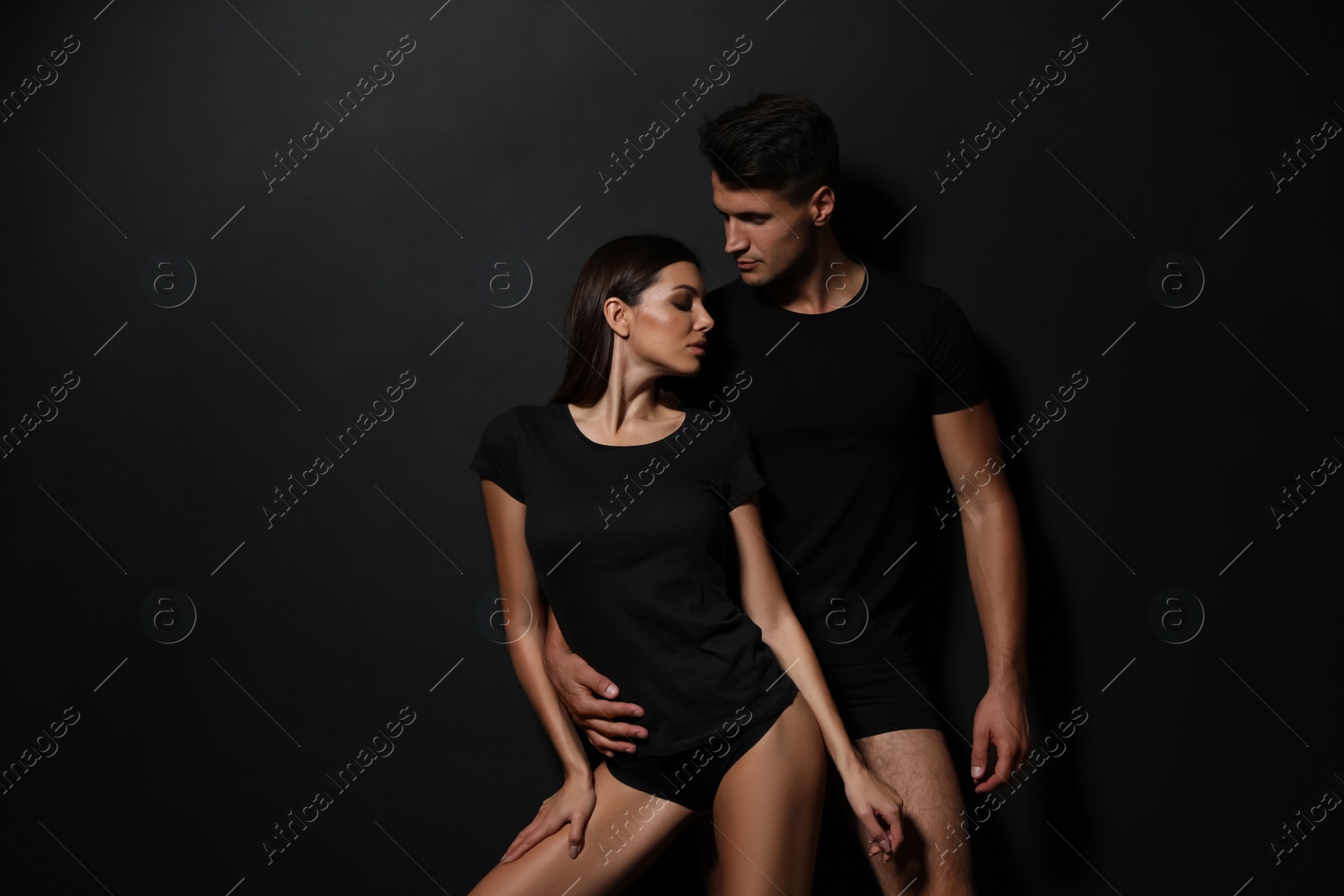 Image of Young couple wearing underwear on black background 