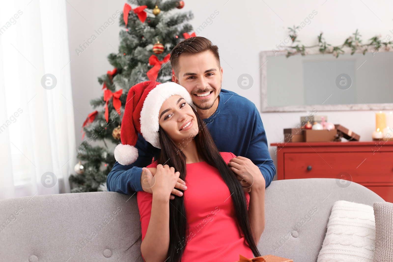 Photo of Happy young couple celebrating Christmas at home