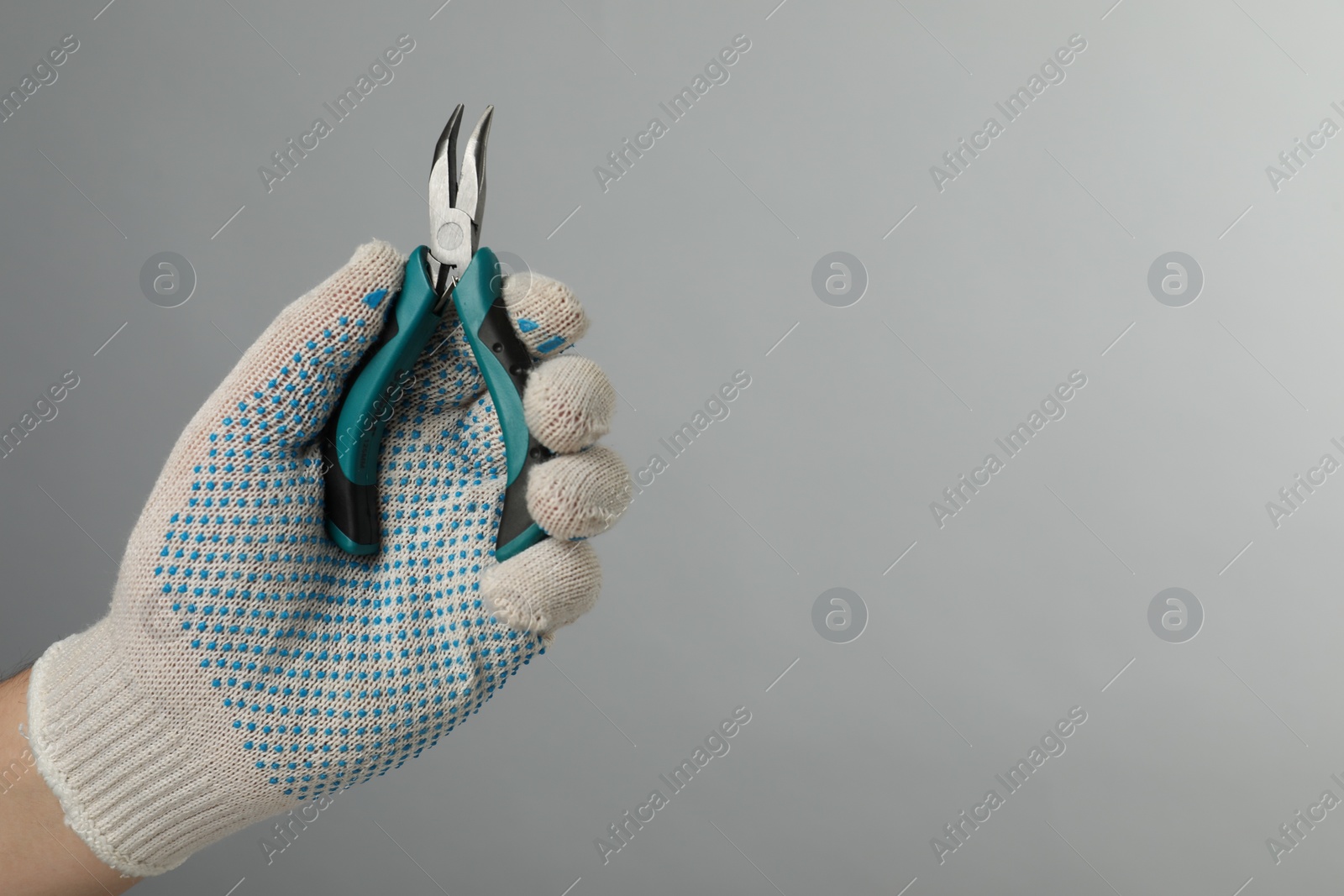 Photo of Man with bent nose pliers on grey background, closeup. Space for text