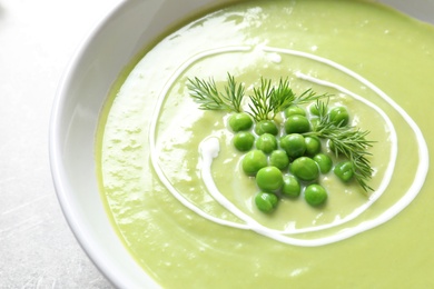 Photo of Fresh vegetable detox soup made of green peas in dish, closeup